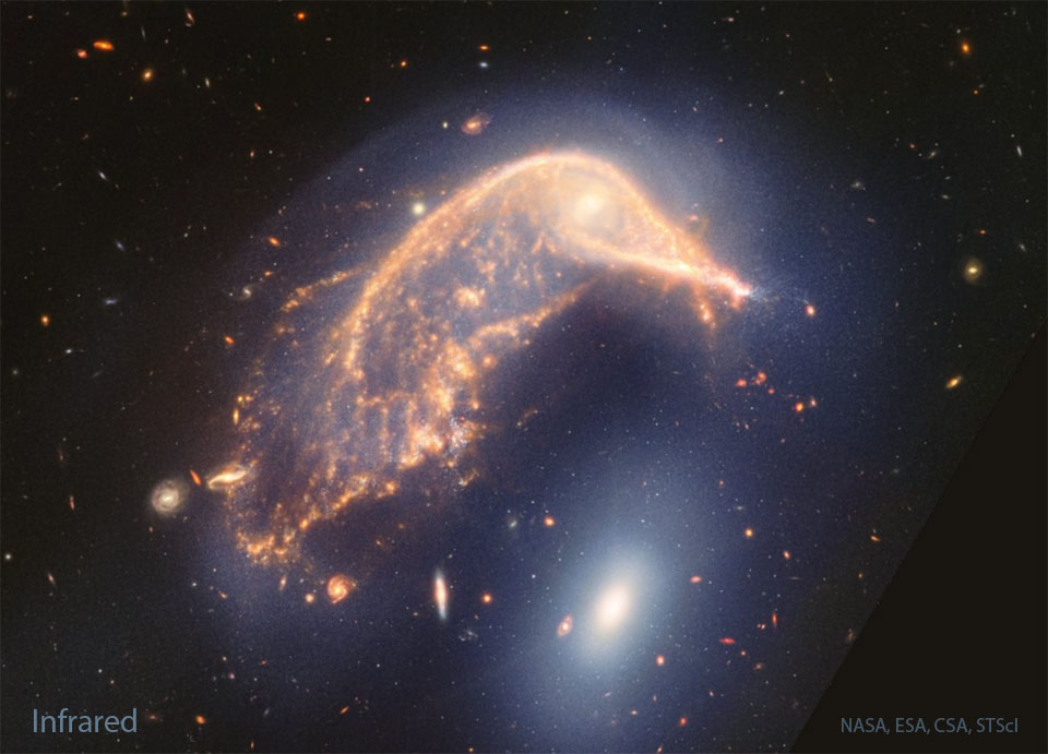 Two large interacting galaxies are shown. The upper
galaxy, has significant internal structure and is curved 
over the lower galaxy which is a featureless oval.  
Please see the explanation for more detailed information.