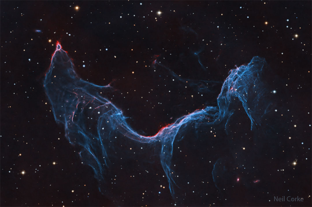 A starfield is shown with a long blue-glowing nebula
taking up much of the frame. The nebula appears, to some,
similar to a fish or a mermaid. 
Please see the explanation for more detailed information.