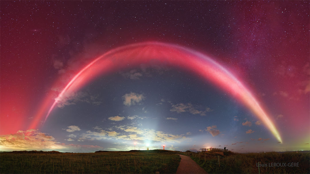 A night sky is shown with a bright red band running
overhead. Above the red band is a diffuse red glow.
A path through a grassy filed is in the foreground
with a path going out toward the horizon. 
Please see the explanation for more detailed information.