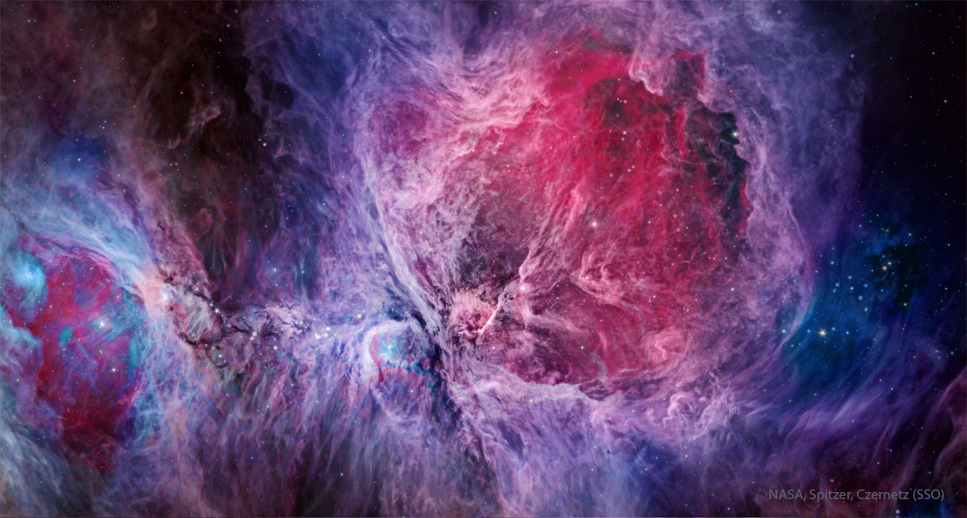A complex nebula fills the frame that is brightly colored,
with red being prominent in the image center and blue being 
most prominent elsewhere. Stars also dot the image. 
Please see the explanation for more detailed information.